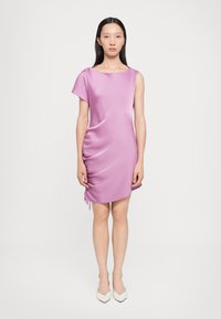 Robe asymétrique à manches courtes en satin violet clair, avec un côté froncé et un détail de cordon, et un ourlet mi-genoux.