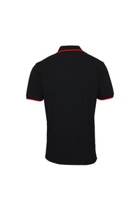 Polo noir avec une coupe slim, manches courtes, accents rouges contrastants sur le col et les ourlets des manches, texture lisse.