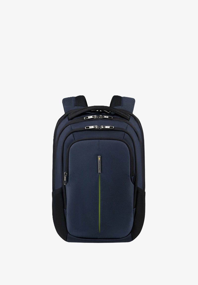 Zaino blu navy con tessuto testurizzato, molteplici scomparti con zip, spallacci imbottiti e una striscia di accentuazione verde.