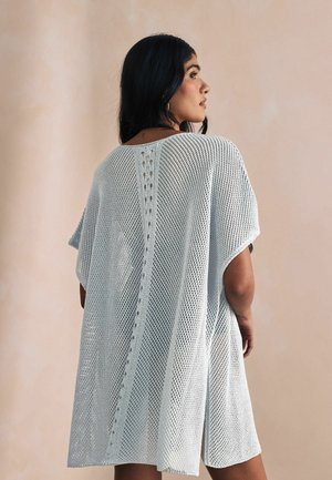 Copertura di maglia aperta azzurro chiaro, vestibilità rilassata, maniche corte, caratterizzata da dettagli verticali lungo la schiena e i lati, ideale per sovrapposizioni.