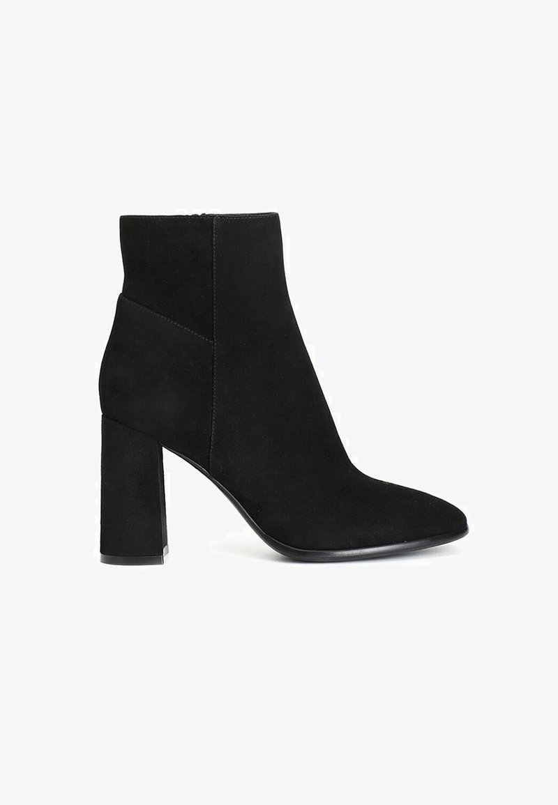Stivaletti neri in suede fino alla caviglia con punta affilata e tacco a blocco spesso. Presentano una texture liscia e dettagli di cucitura minimali.