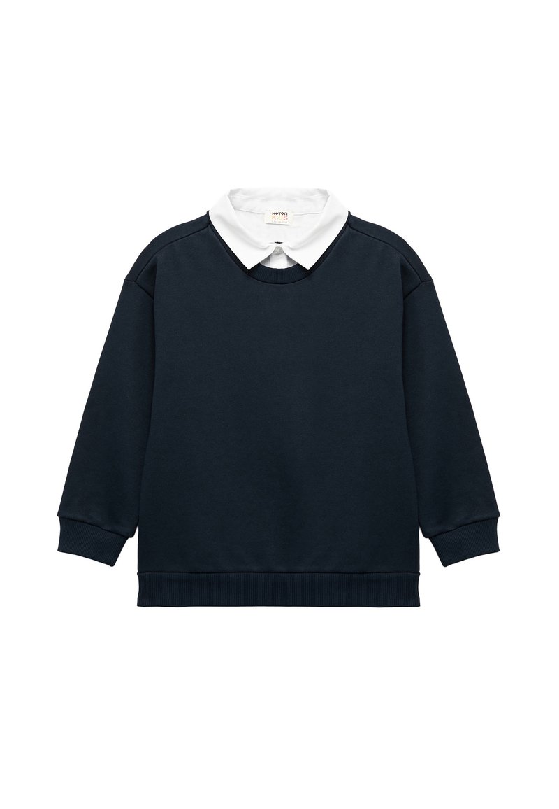 Sudadera azul marino con una camisa blanca de cuello debajo. Presenta puños y dobladillo acanalados. Elaborada en un tejido suave y texturizado con un corte relajado.
