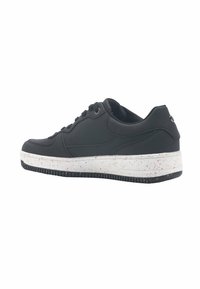 Czarne skórzane sneakersy o niskim fasonie, z białą podeszwą w czerwone kropki i czarną gumową podeszwą z teksturowaniem.