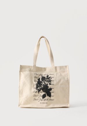 Beige handlenett med doble håndtak, svart blomsterdesign og gjentatt "Karl Lagerfeld Jeans" tekst på forsiden.