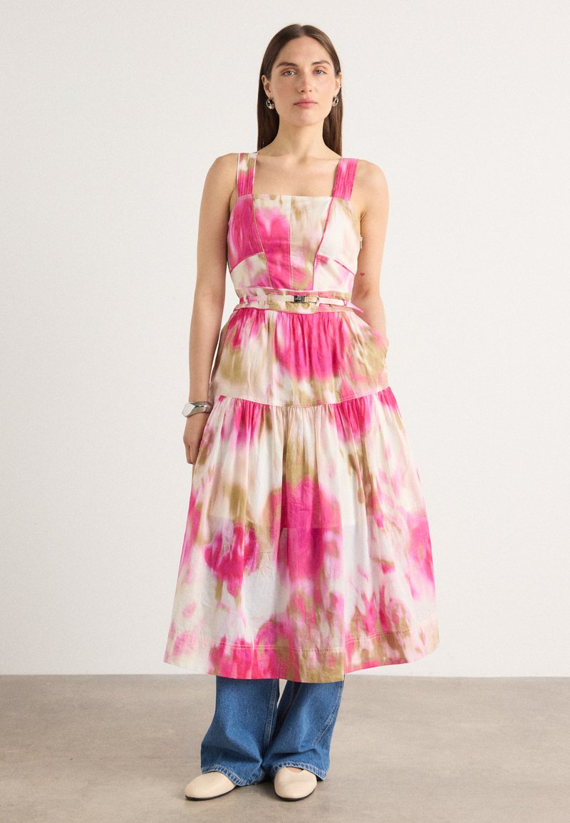 Robe colorée à motif floral en rose et beige, fabriquée en tissu léger, avec un corsage ajusté, de larges bretelles et une jupe en couches.