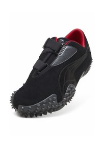 Sort og rød sportssko med tekstureret, pigget sål, to sorte remme over toppen og sort og sølv sidebemærkning.