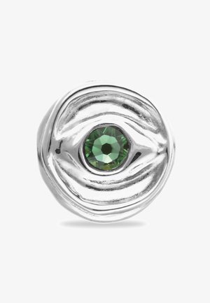 Bague en argent avec un design ondulé, ornée d'un cristal vert rond central. La finition polie met en valeur la texture et les détails du métal.