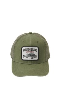 Gorra verde oliva con un panel de tela en la parte frontal y lados de malla. Presenta un parche rectangular con un gráfico de un pez y el texto "KOROSHI BRAND EST.2001".