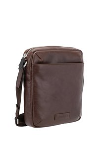 Borsa a tracolla in pelle marrone con una texture liscia, chiusura con zip e tracolla regolabile. Presenta una tasca frontale e un dettaglio di branding discreto.