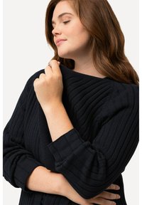 Navyblå randig tröja i strukturerad stickning, med en avslappnad passform och uppväljda ärmar, bred rundad halsringning och subtilt mönster.