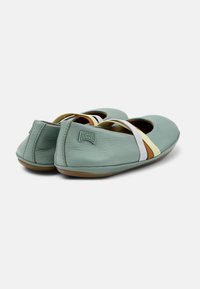 Bailarinas de cuero verde menta con forma redondeada y correas elásticas en marfil, amarillo y marrón. Cuentan con una suela de goma y logo de la marca.
