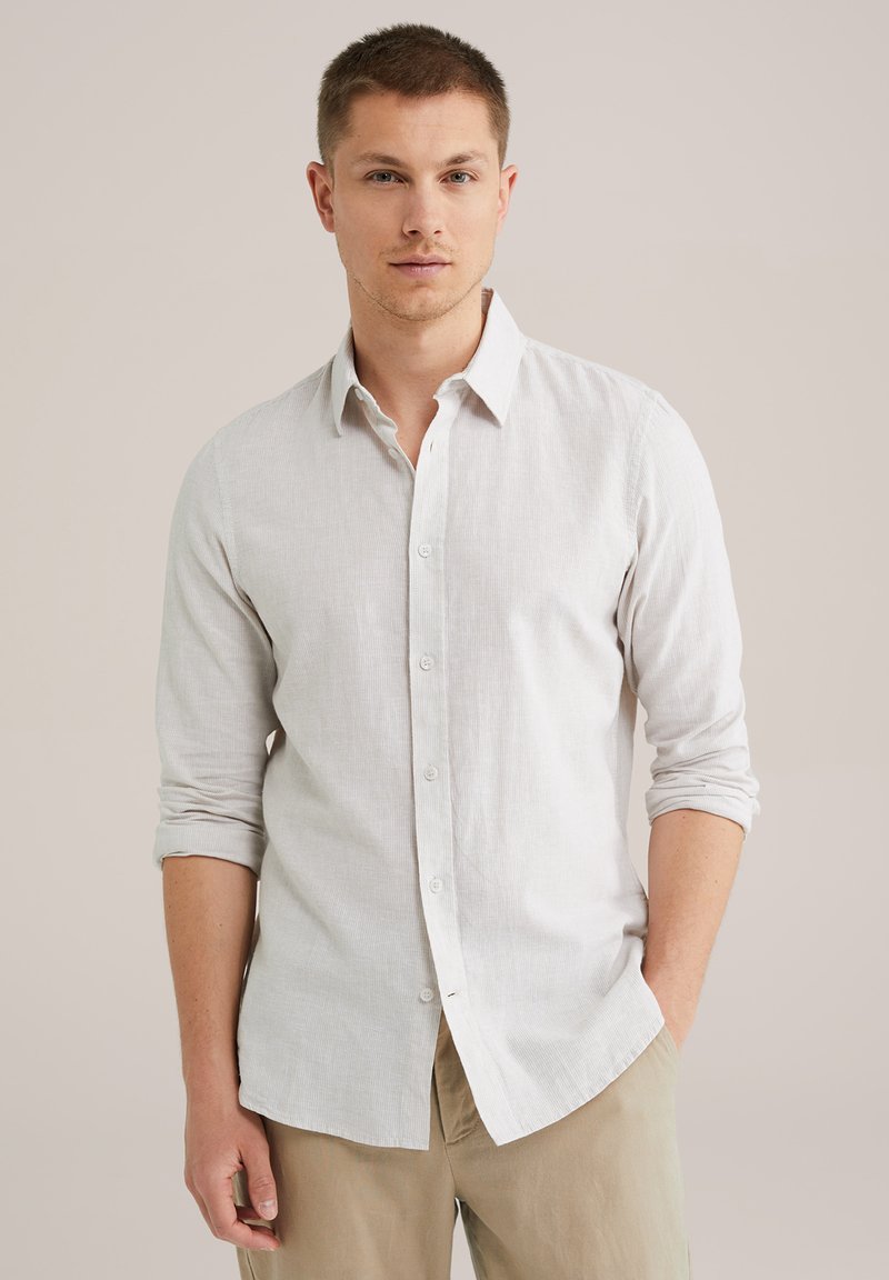 Camisa de botones gris claro hecha de un tejido texturizado con mangas largas enrolladas en los puños, presenta un cuello clásico y una tapeta frontal.