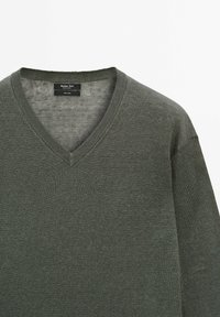 Maglione a V con maniche lunghe in tessuto a maglia verde scuro. Presenta un collo a coste e una texture liscia. Etichetta del marchio visibile all'interno del colletto.