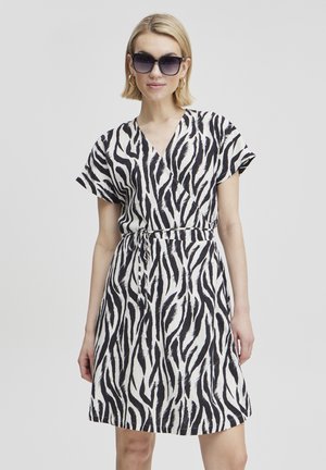 Short-sleeve, wrap dress in a zebra print design featuring black and white stripes, with a tied waist for a fitted look.
