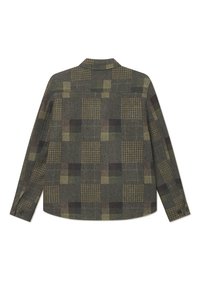 Jachetă din lână de culoare verde închis cu un design cu modele și carouri. Manșete cu nasturi și un tiv drept.