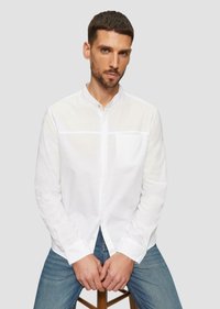 Witte langemouwige overhemden met knopen en een bandkraag, met een subtiele textuur en een borstzak, gecombineerd met blauwe jeans.