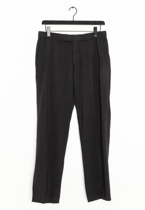 Schwarze formelle Hose mit Gürtelschlaufen und vorderen Falten, aufgehängt an einem schwarzen Kleiderbügel vor weißem Hintergrund.