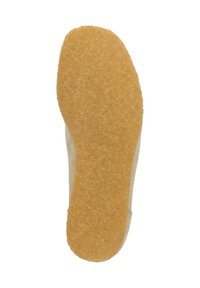 Wildledersohle, strukturiert mit einem gelblichen Gummi-Material, das eine glatte, abgerundete Form und leichte Unregelmäßigkeiten für besseren Halt aufweist.