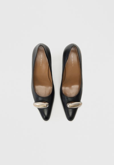 Zwarte leren hoge hakken met een spitse neus en een decoratieve gouden accent. De binnenvoering is van bruin leer met een gladde textuur.