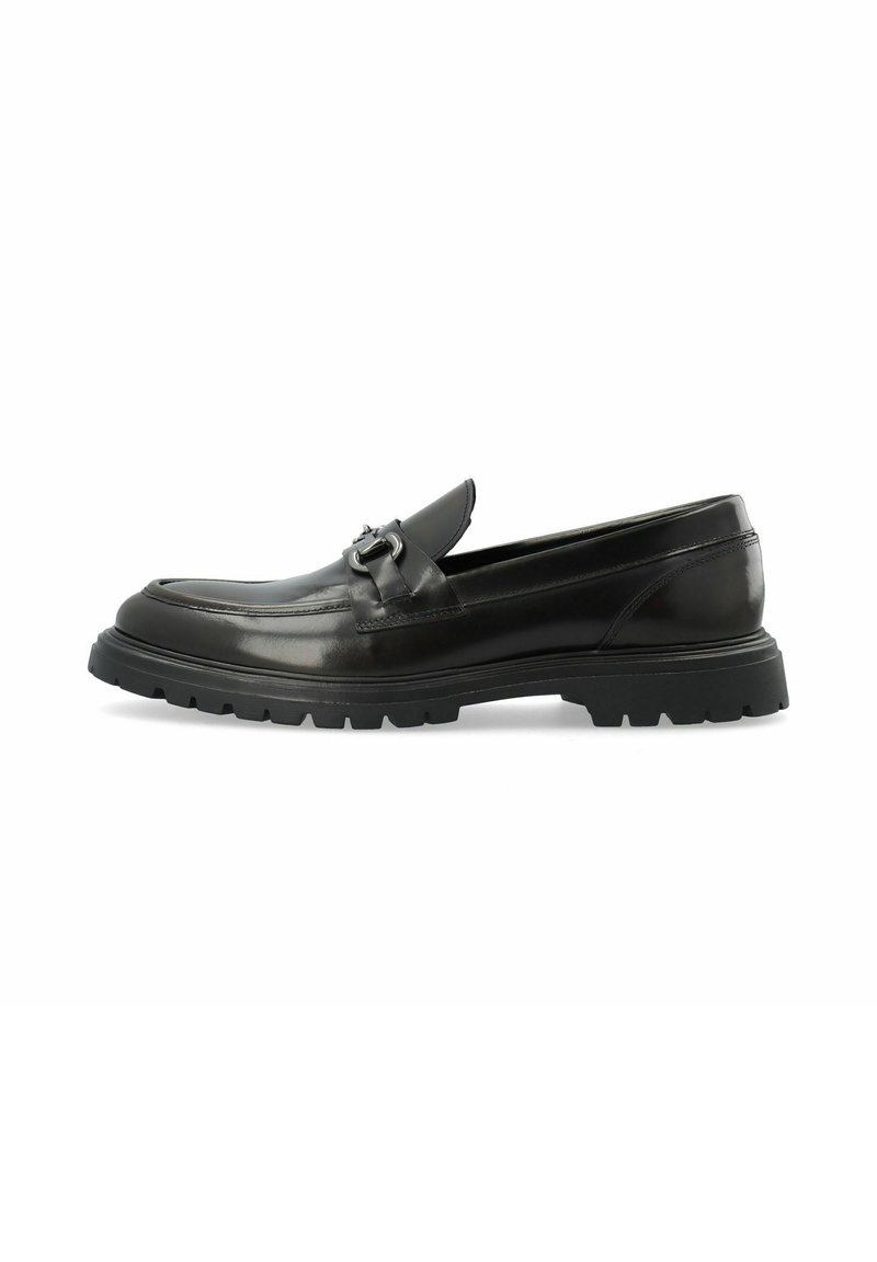 Mocasines de cuero negro con punta redonda, detalle de costura y un acento metálico decorativo. Suela de goma gruesa para tracción y durabilidad.