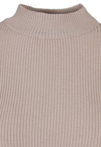 Ribbed knit turtleneck in a soft beige color. The fabric features vertical lines and an elastic texture around the neck and upper body.