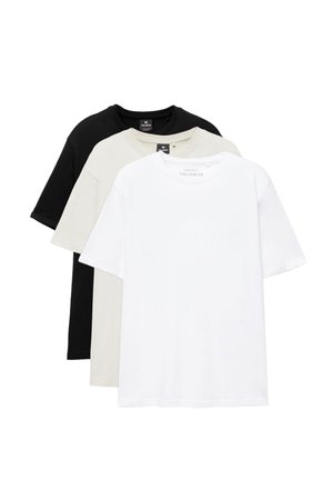 Sæt med tre ensfarvede crewneck-T-shirts i sort, beige og hvid, pænt stablet med korte ærmer og synlige mærkeetiketter indeni kraverne.