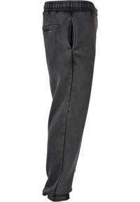 Sorte, glatte stof joggerbukser med elastisk talje, sidelommer og tapered manchetter ved anklerne.