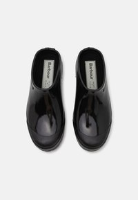 Black waterproof clogs with a glossy finish and textured black rubber trim, featuring a slip-on design and cushioned interior.