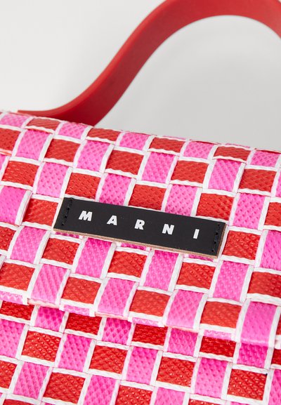 Borsa in plastica intrecciata di colore rosso e rosa con motivo a griglia, dotata di una superficie testurizzata e un'etichetta con logo nero in evidenza. Manico rosso.