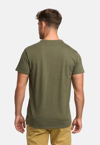 Olive green cotton t-shirt with short sleeves, crew neckline, and a relaxed fit, featuring a small logo detail at the lower hem.