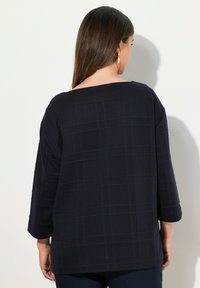 Top over-size blu navy con scollatura quadrata, maniche a tre quarti, tessuto testurizzato e motivo a griglia. Adatto per un abbigliamento casual.
