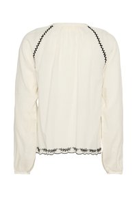 Cremefarvet bluse med lange ærmer, der har sort broderet detalj langs halsudskæringen og kanten, med samlet tekstur ved skuldrene og ryggen.