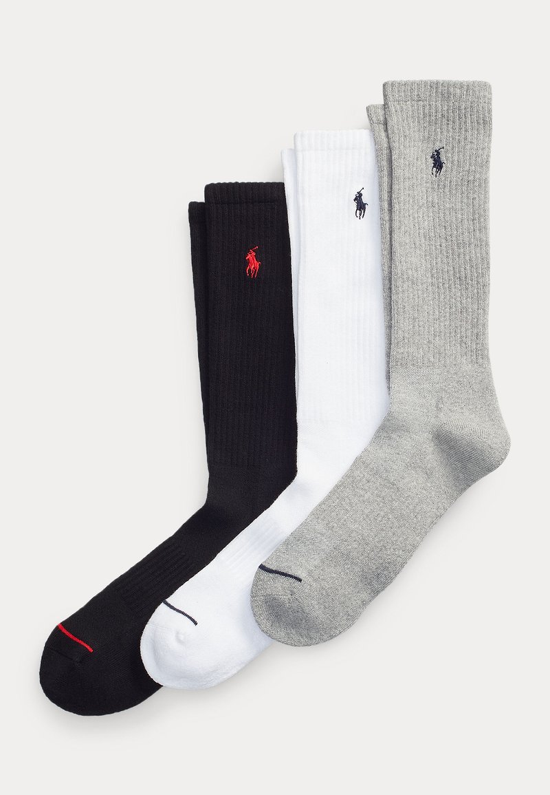 Trois paires de chaussettes montantes côtelées en noir, blanc et gris, chacune avec un petit logo de joueur de polo brodé près du haut.
