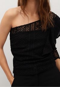 Top nero con design a spalla unica, caratterizzato da materiale in pizzo intricato e dettagli texturizzati. Manica corta dall'altro lato.