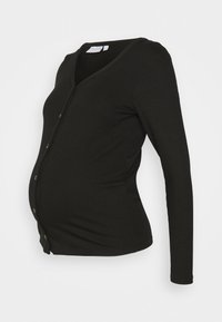 Svart ribbad långärmad graviditetsjacka med V-ringning och tryckknappar, visad på en torso mannekäng mot en vit bakgrund.