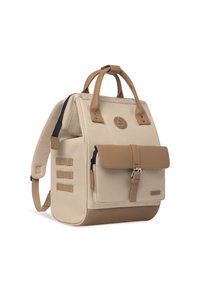 Sac à dos beige avec des accents en cuir tan, deux poignées supérieures, des bretelles réglables et un rabat avant sécurisé par une boucle. Comprend trois sangles latérales.