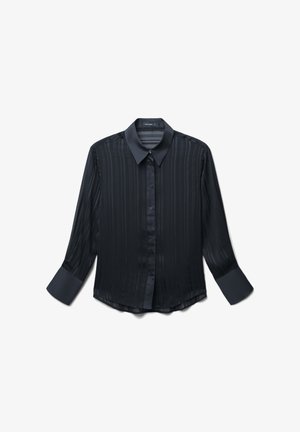 Chemisier noir à manches longues, avec un col pointu, un motif à rayures verticales et de larges poignets sur fond blanc.