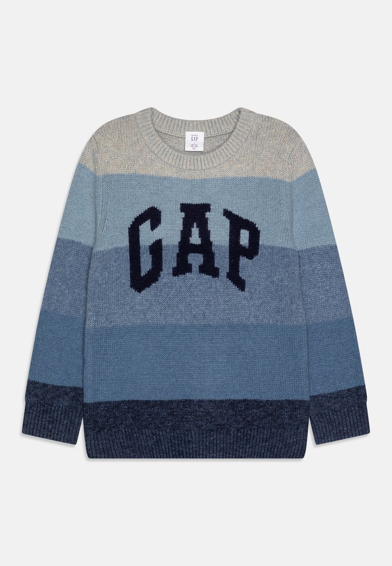 Pull en maille épaisse à rayures horizontales beige et nuances de bleu, avec de grandes lettres noires "GAP" sur la poitrine.