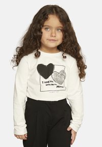 Camicia bianca a maniche lunghe con stampa grafica di due cuori, uno nero e uno con paillettes, con la scritta "Ti amo con tutto il mio cuore."