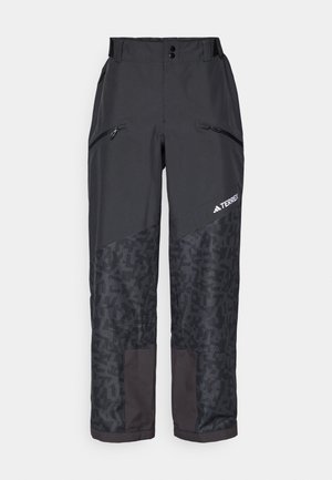 Pantalons d'extérieur noirs avec une partie inférieure à motif, dotés de poches zippées et d'un léger éclat. Fabriqués en matériau durable et résistant aux intempéries.