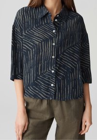 Camicia blu navy con motivo geometrico grigio, maniche a tre quarti e colletto, realizzata in tessuto leggero.