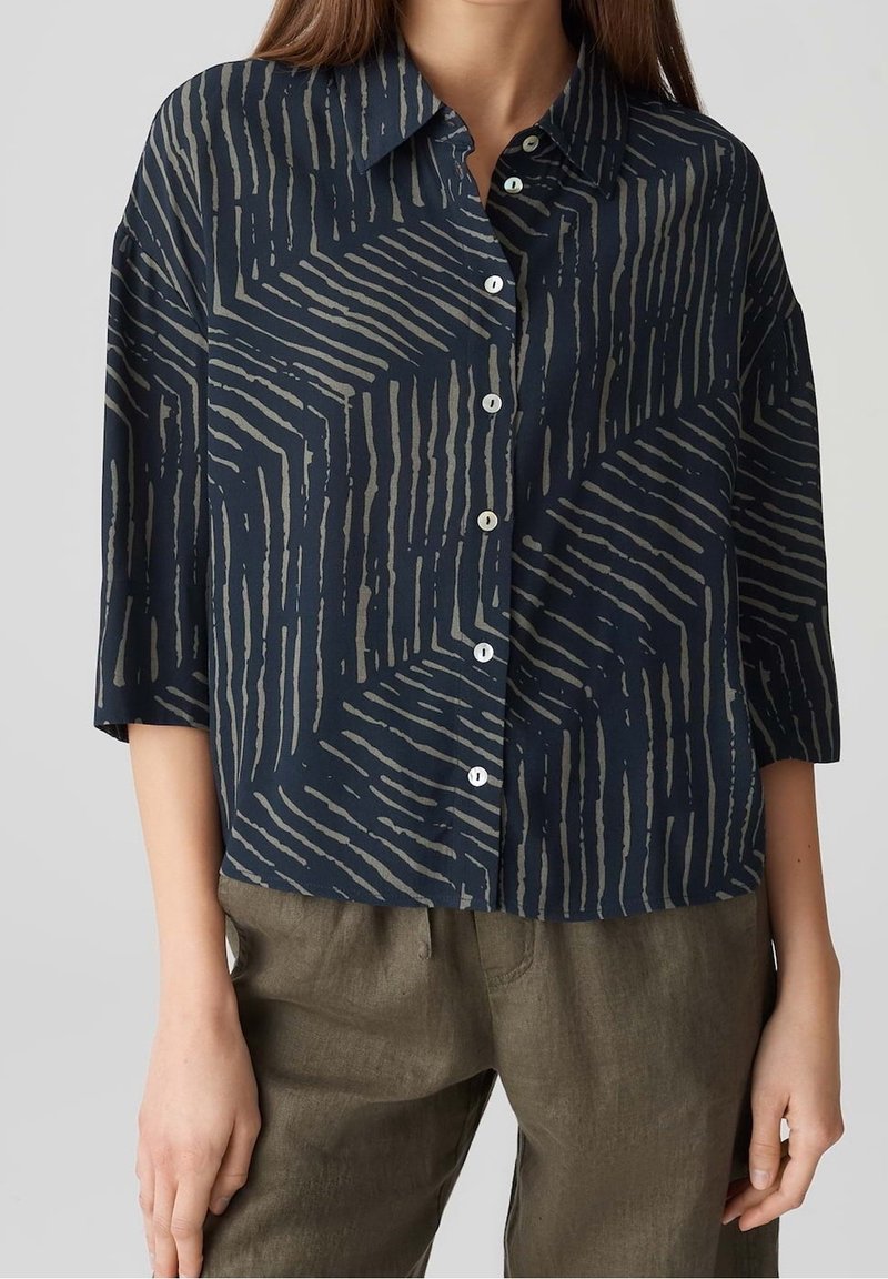 Camicia blu navy con motivo geometrico grigio, maniche a tre quarti e colletto, realizzata in tessuto leggero.
