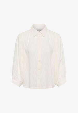 Fehér, gombos ing gallérral, felfújt ujjakkal és mintás cikkcakk mintával. Könnyű anyagból készült.