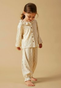 Set voor kinderpajama in zacht crèmekleurig stof met subtiel bloemenpatroon, voorzien van een gekrulde kraag, een knoopsluiting bovenaan, en gathered enkels op de broek.