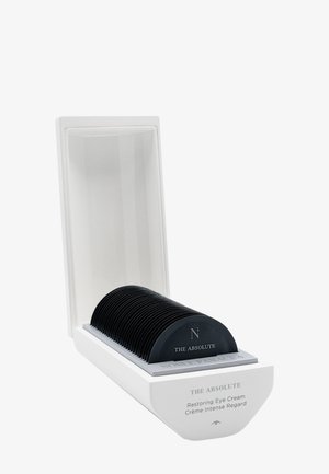 Boîte rectangulaire blanche avec couvercle ouvert contenant des contenants noirs incurvés étiquetés The Absolute Restoring Eye Cream.