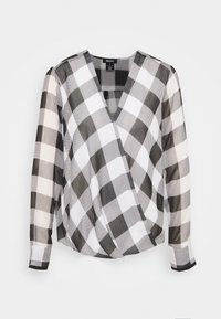 Blouse à manches longues noir et blanc à motifs à carreaux, avec un col en V et un devant croisé, fabriquée par DKNY.