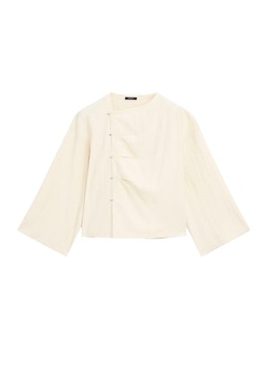 Light beige cropped blouse with wide sleeves, featuring a rounded neckline and five decorative buttons on the front for closure.