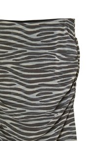 Un tessuto a motivi con strisce ondulate grigie e crema, con una superficie texturizzata e un dettaglio arricciato su un lato.