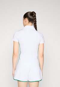 White short-sleeve dress with green accents and piping, featuring a collared neckline and a fitted silhouette, shown from the back.