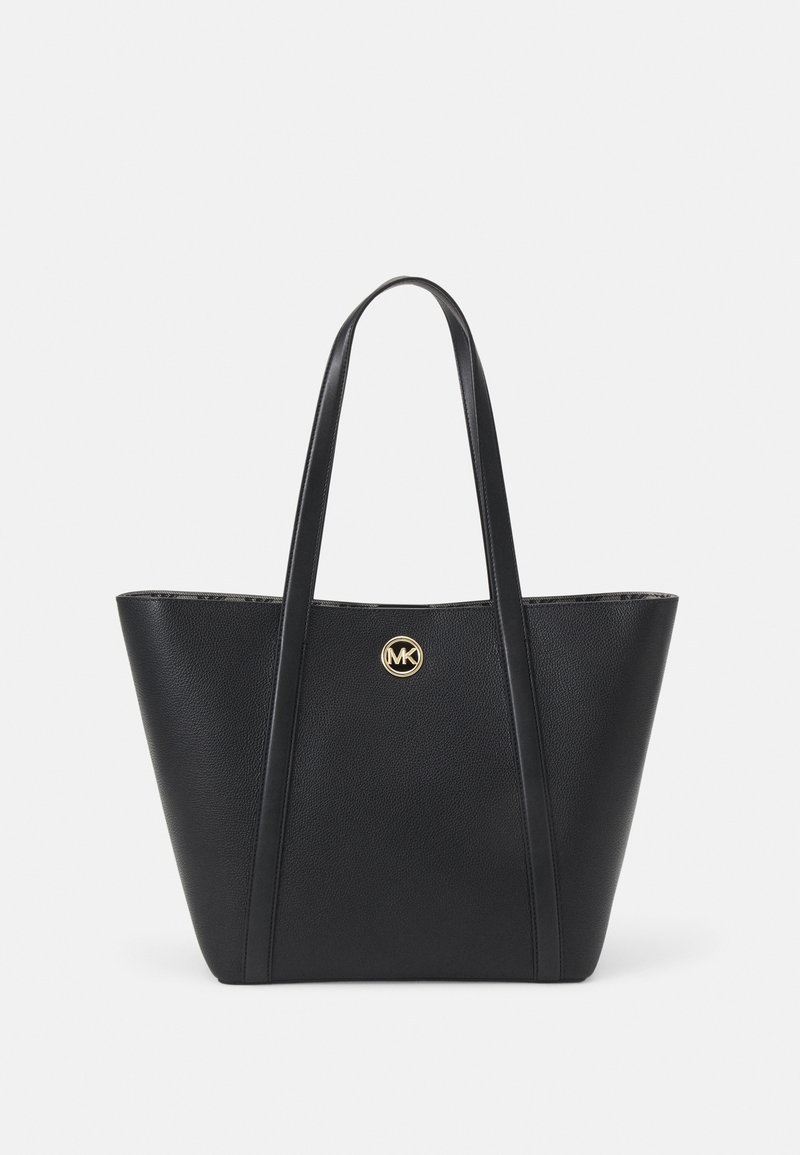 Sac cabas en cuir noir avec deux longues anses et un petit logo circulaire doré MK centré à l'avant.
